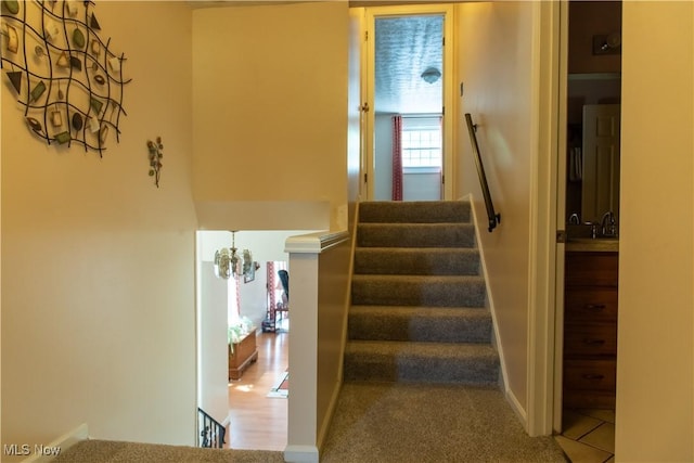 7969 Bricker Rd NW, Massillon, OH 44646 - staircase featuring a chandelier and carpet