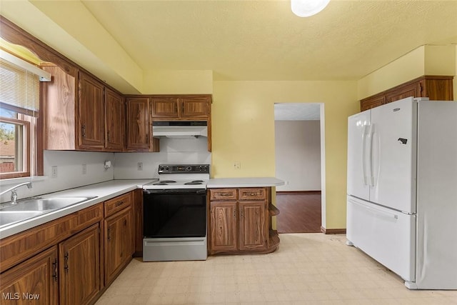 67 Chestnut Ave, Northfield, OH 44067 - kitchen with freestanding refrigerator, electric range oven, light flooring, under cabinet range hood, and light countertops
