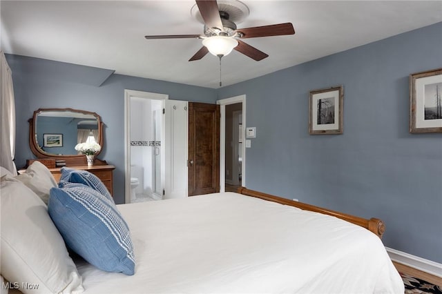 bedroom featuring baseboards, wood finished floors, connected bathroom, and a ceiling fan