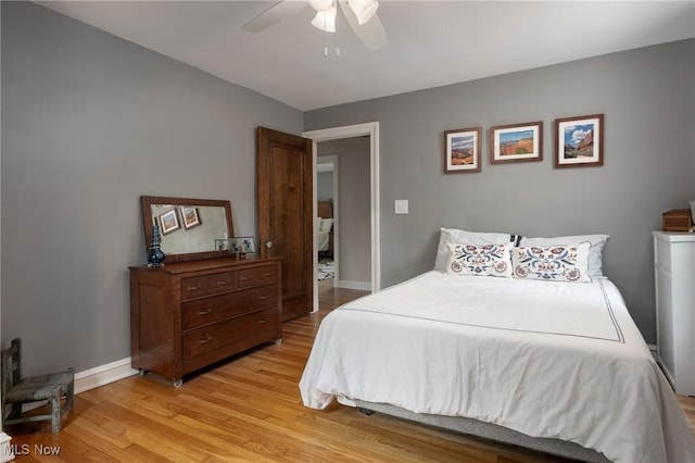 bedroom with light wood-style floors, ceiling fan, and baseboards
