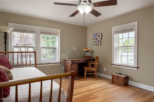 office area featuring light wood-style flooring, baseboards, and a ceiling fan