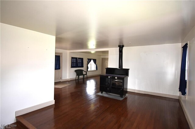 7833 Pymatuning Lake Rd, Williamsfield, OH 44093 - living area with a wood stove, wood finished floors, and baseboards