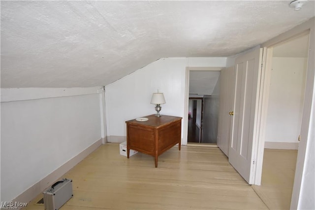 7833 Pymatuning Lake Rd, Williamsfield, OH 44093 - additional living space featuring light wood-style flooring, vaulted ceiling, and a textured ceiling