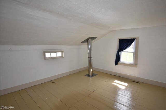 7833 Pymatuning Lake Rd, Williamsfield, OH 44093 - bonus room featuring lofted ceiling, baseboards, plenty of natural light, a textured ceiling, and wood finished floors