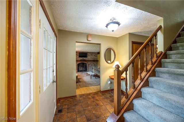 8665 Prescott Dr, Chesterland, OH 44026 - entryway featuring a textured ceiling, stairway, baseboards, and a brick fireplace
