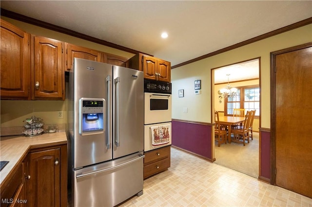 8665 Prescott Dr, Chesterland, OH 44026 - kitchen with stainless steel refrigerator with ice dispenser, light countertops, a chandelier, double oven, and ornamental molding