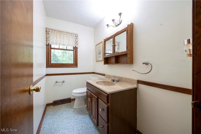 8665 Prescott Dr, Chesterland, OH 44026 - half bath featuring vanity, toilet, a textured ceiling, and baseboards