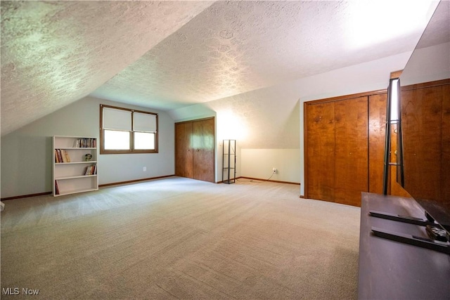 8665 Prescott Dr, Chesterland, OH 44026 - additional living space featuring vaulted ceiling, a textured ceiling, baseboards, and carpet floors