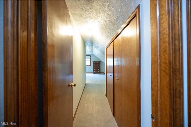 8665 Prescott Dr, Chesterland, OH 44026 - hallway featuring a textured ceiling, carpet flooring, vaulted ceiling, and baseboards