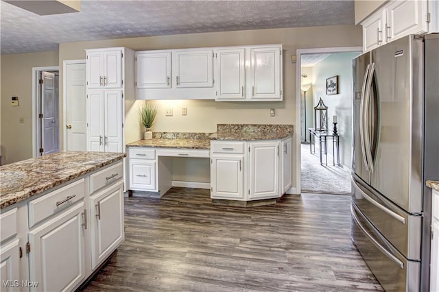 650 Thornhill Ln, Aurora, OH 44202 - kitchen with freestanding refrigerator, a textured ceiling, dark wood-type flooring, white cabinetry, and light stone counters