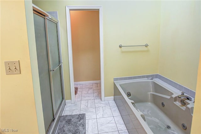 650 Thornhill Ln, Aurora, OH 44202 - bathroom featuring marble look tile flooring, a stall shower, a jetted tub, and baseboards