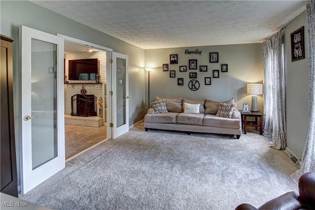 650 Thornhill Ln, Aurora, OH 44202 - living area with carpet, a textured ceiling, a fireplace, and french doors