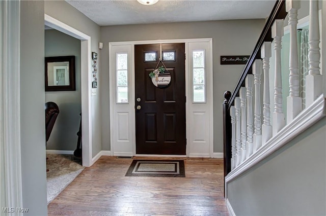650 Thornhill Ln, Aurora, OH 44202 - entrance foyer with stairs, hardwood / wood-style flooring, baseboards, and a textured ceiling