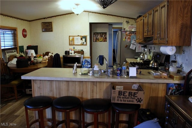 3560 Orchard Unit A-22, Stow, OH 44224 - kitchen featuring lofted ceiling, stainless steel appliances, a peninsula, wood finished floors, and light countertops