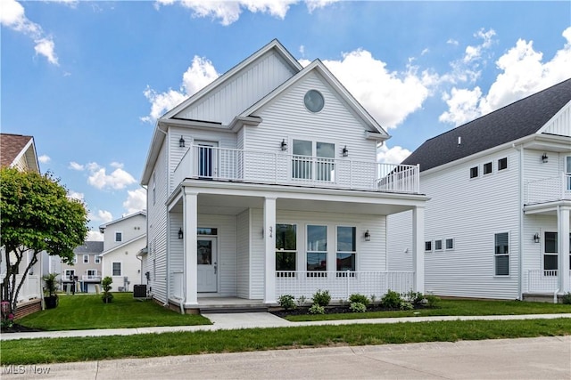 374 Bascule Dr, Lorain, OH 44052 - view of front facade with a balcony, covered porch, a front yard, and board and batten siding