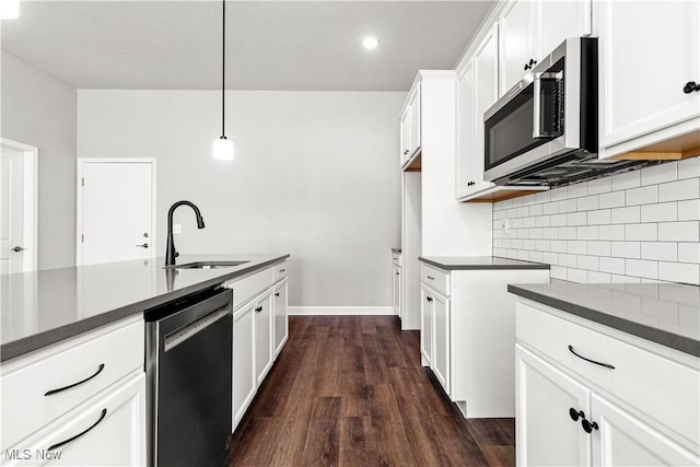 374 Bascule Dr, Lorain, OH 44052 - kitchen featuring stainless steel appliances, dark countertops, tasteful backsplash, dark wood-style flooring, and white cabinetry