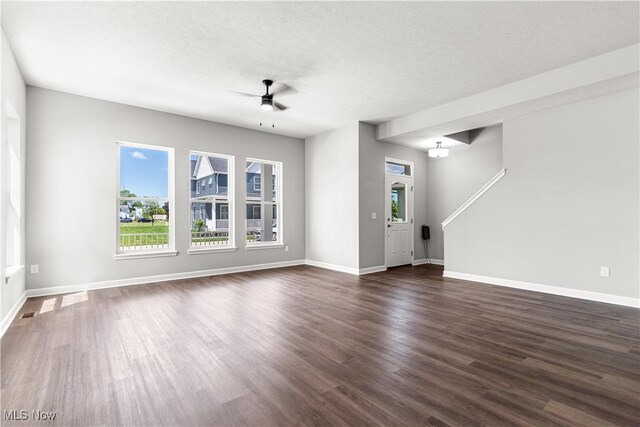 374 Bascule Dr, Lorain, OH 44052 - unfurnished living room with a ceiling fan, healthy amount of natural light, dark wood-type flooring, and a textured ceiling