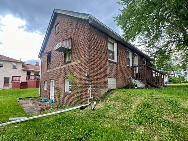 39 Wayne St, Niles, OH 44446 - view of property exterior with brick siding and a lawn
