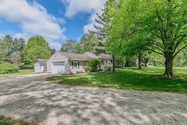 13970 E Willard Rd, Novelty, OH 44072 - view of front facade featuring an attached garage, a shed, a front lawn, driveway, and an outbuilding