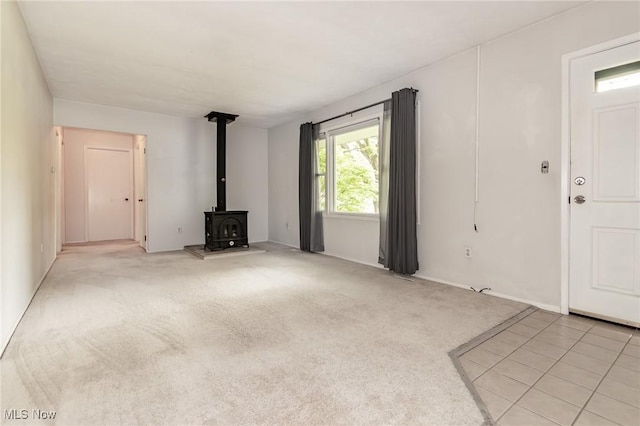13970 E Willard Rd, Novelty, OH 44072 - unfurnished living room featuring a wood stove, light carpet, and baseboards