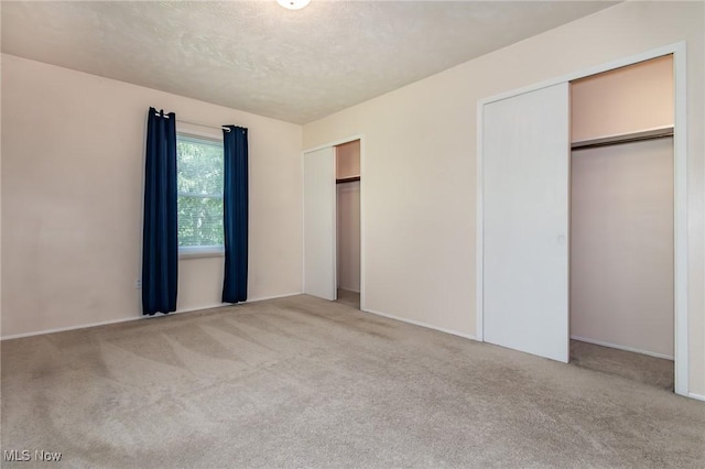 13970 E Willard Rd, Novelty, OH 44072 - unfurnished bedroom with carpet flooring, multiple closets, baseboards, and a textured ceiling