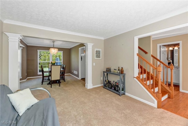 living room featuring ornate columns, light carpet, stairway, baseboards, and ornamental molding