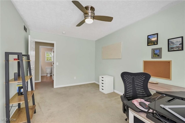 office space with a ceiling fan, light carpet, a textured ceiling, and baseboards