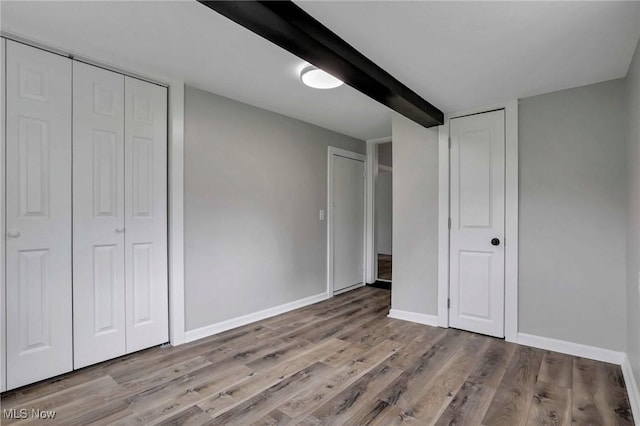 35 W 5th St, Dresden, OH 43821 - unfurnished bedroom with wood finished floors, baseboards, and beam ceiling