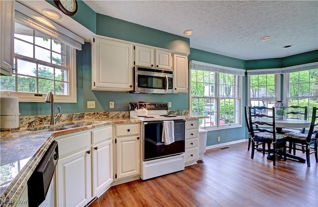 401 Bounty Way, Avon Lake, OH 44012 - kitchen featuring stainless steel microwave, range with electric cooktop, a sink, dishwashing machine, and light wood finished floors