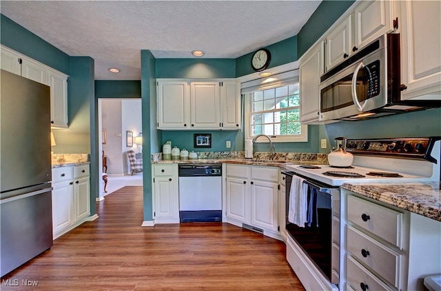 401 Bounty Way, Avon Lake, OH 44012 - kitchen with stainless steel appliances, a sink, light stone countertops, white cabinetry, and wood finished floors