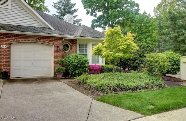 401 Bounty Way, Avon Lake, OH 44012 - view of front of home with driveway, an attached garage, brick siding, roof with shingles, and a chimney