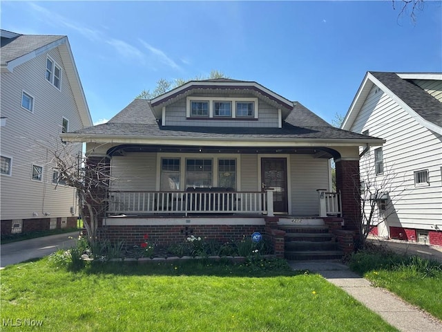 4212 W 48th St, Cleveland, OH 44144 - bungalow-style home featuring covered porch, a front lawn, and a shingled roof
