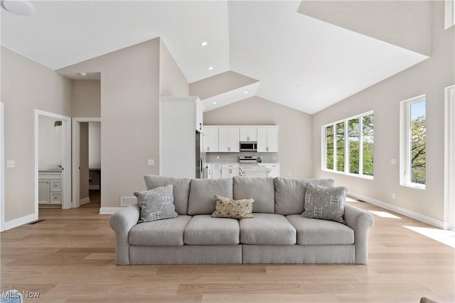 26 Oneida Trl, Malvern, OH 44644 - living area featuring high vaulted ceiling, light wood-style floors, recessed lighting, and baseboards
