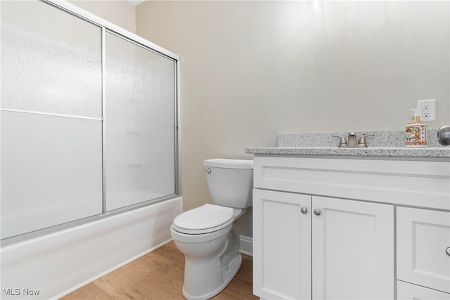 26 Oneida Trl, Malvern, OH 44644 - full bath with toilet, vanity, wood finished floors, shower / bath combination with glass door, and baseboards