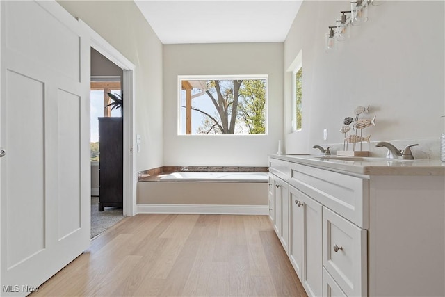 26 Oneida Trl, Malvern, OH 44644 - bathroom with wood finished floors, a bath, vanity, and baseboards