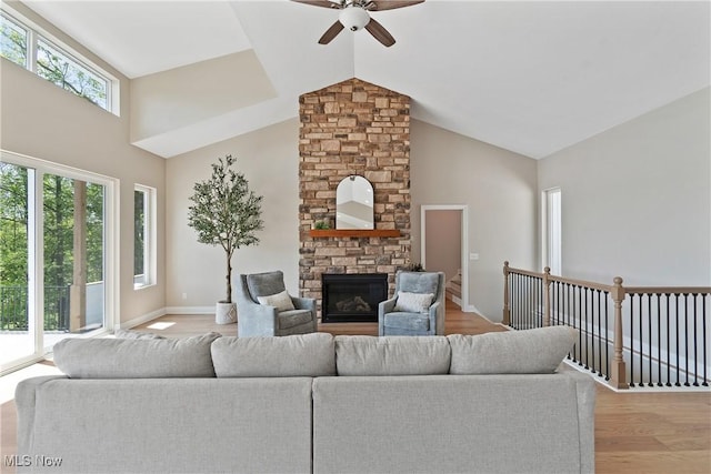 26 Oneida Trl, Malvern, OH 44644 - living room featuring ceiling fan, a stone fireplace, high vaulted ceiling, light wood finished floors, and baseboards