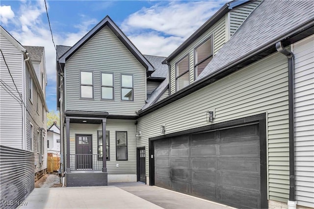 view of front of property with an attached garage, driveway, and fence