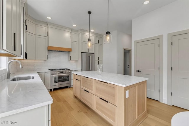 kitchen with stainless steel appliances, a sink, light wood-type flooring, decorative backsplash, and recessed lighting