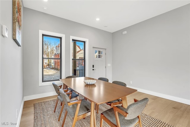dining room with baseboards, wood finished floors, and recessed lighting