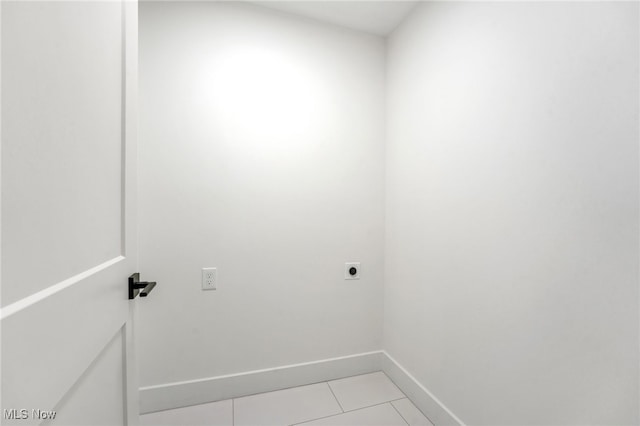 laundry room with electric dryer hookup, baseboards, and light tile patterned flooring