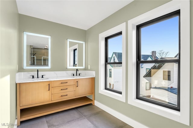 full bath with double vanity, tile patterned flooring, and baseboards