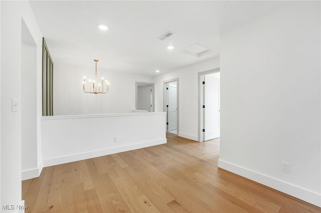 spare room featuring light wood finished floors, baseboards, a chandelier, and recessed lighting