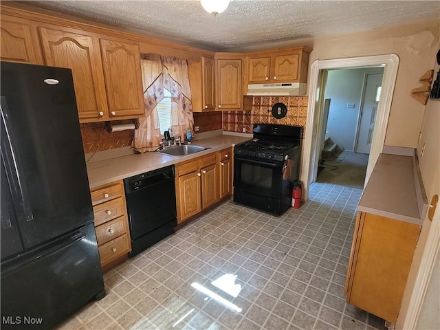 9788 E River Rd, Elyria, OH 44035 - kitchen with black appliances, under cabinet range hood, a sink, a textured ceiling, and light countertops