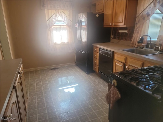 9788 E River Rd, Elyria, OH 44035 - kitchen with black appliances, a sink, healthy amount of natural light, and baseboards