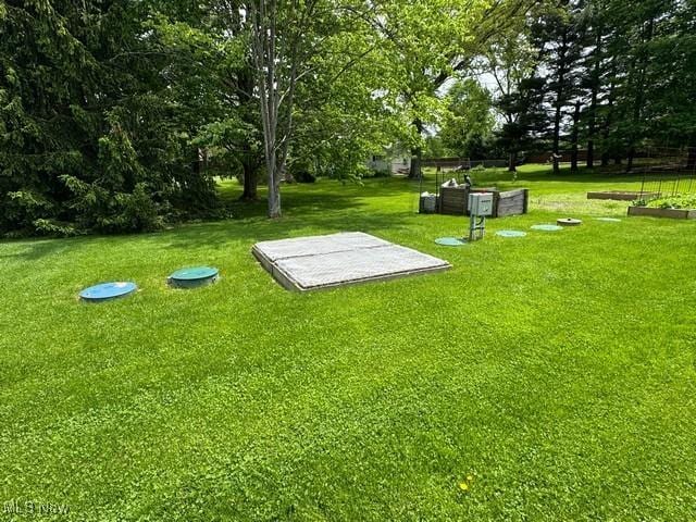 view of home's community featuring a lawn and view of wooded area