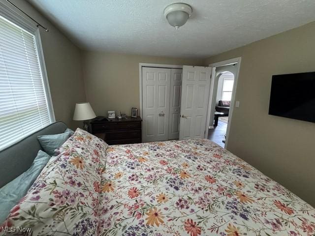 bedroom with arched walkways and a closet