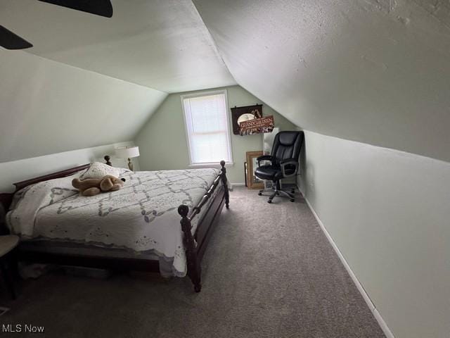 carpeted bedroom featuring lofted ceiling and baseboards