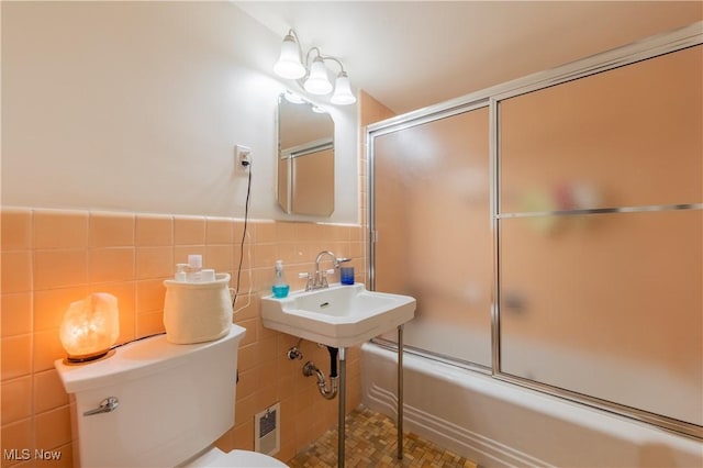 13710 Shaker Blvd Unit 405, Cleveland, OH 44120 - bathroom with tile walls, toilet, combined bath / shower with glass door, and a wainscoted wall