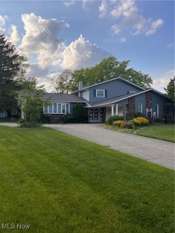 2840 Brian Dr, Parma, OH 44134 - view of front of property with a chimney, a front yard, and driveway