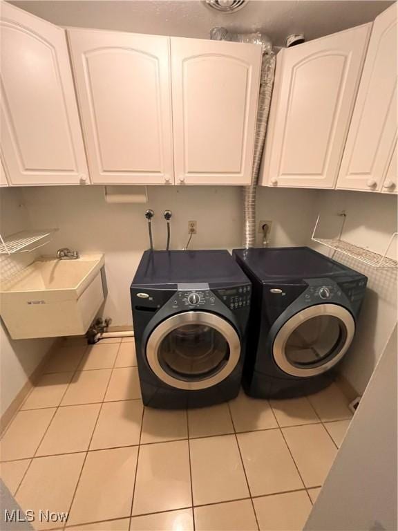2840 Brian Dr, Parma, OH 44134 - laundry area featuring cabinet space, washing machine and clothes dryer, and tile patterned flooring